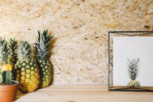 A modern interior design featuring pineapples and a framed pineapple print for decorative inspiration.