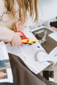 Close-up of a person cutting magazine pages for a creative collage project.